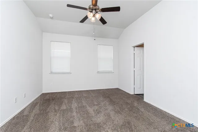 an empty room with chandelier fan