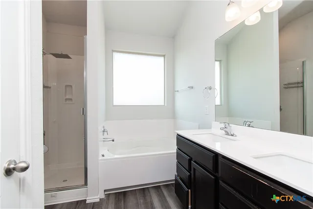 a bathroom with a bathtub a sink a vanity and a mirror