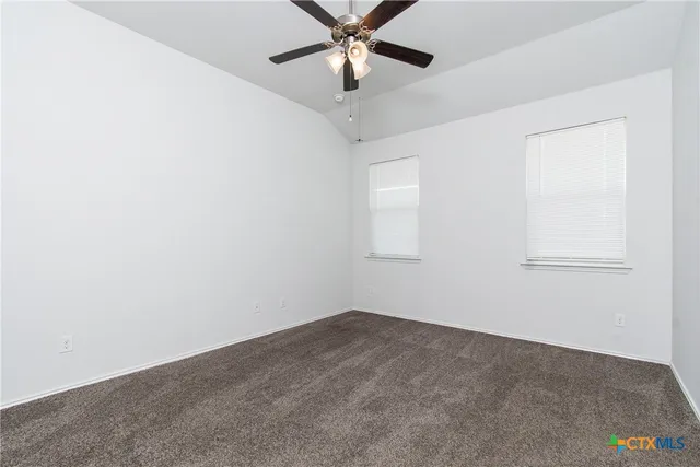 an empty room with a window and a fan