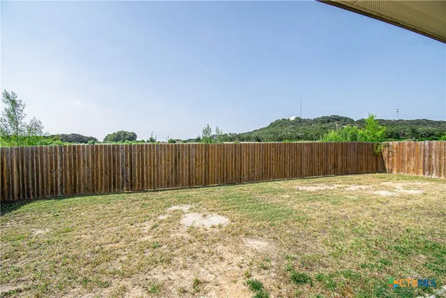 a view of a backyard with wooden fence