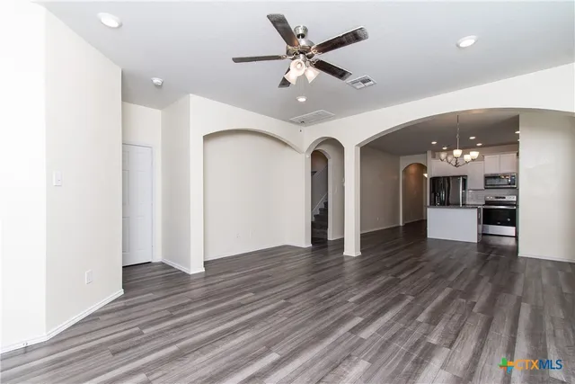 wooden floor in an empty room with a kitchen