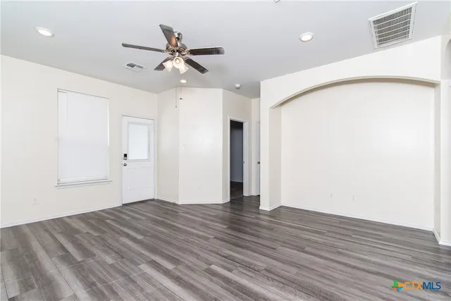 a view of an empty room with wooden floor