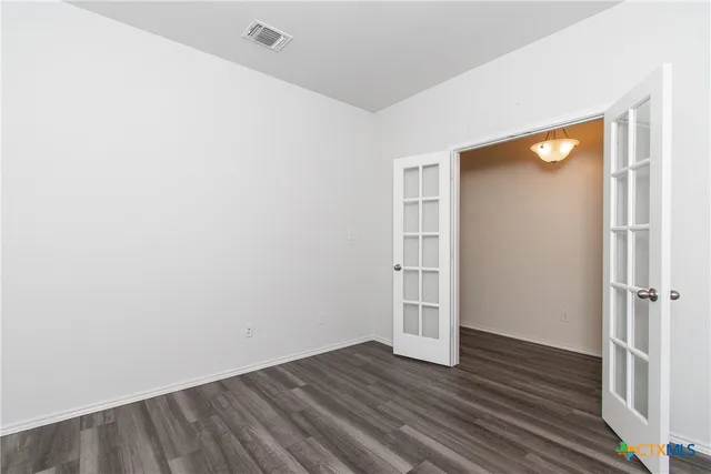an empty room with wooden floor and closet