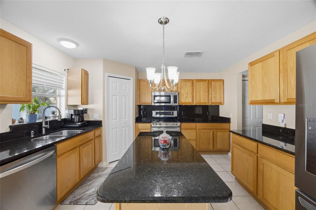 4517 Southeast 28th Street Ocala, FL 34480 - Photo 16 of 43 a large kitchen with kitchen island granite countertop a large window and a counter space