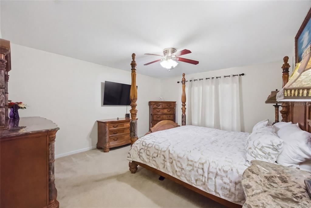 4517 Southeast 28th Street Ocala, FL 34480 - Photo 18 of 43 a bedroom with a bed and a flat screen tv