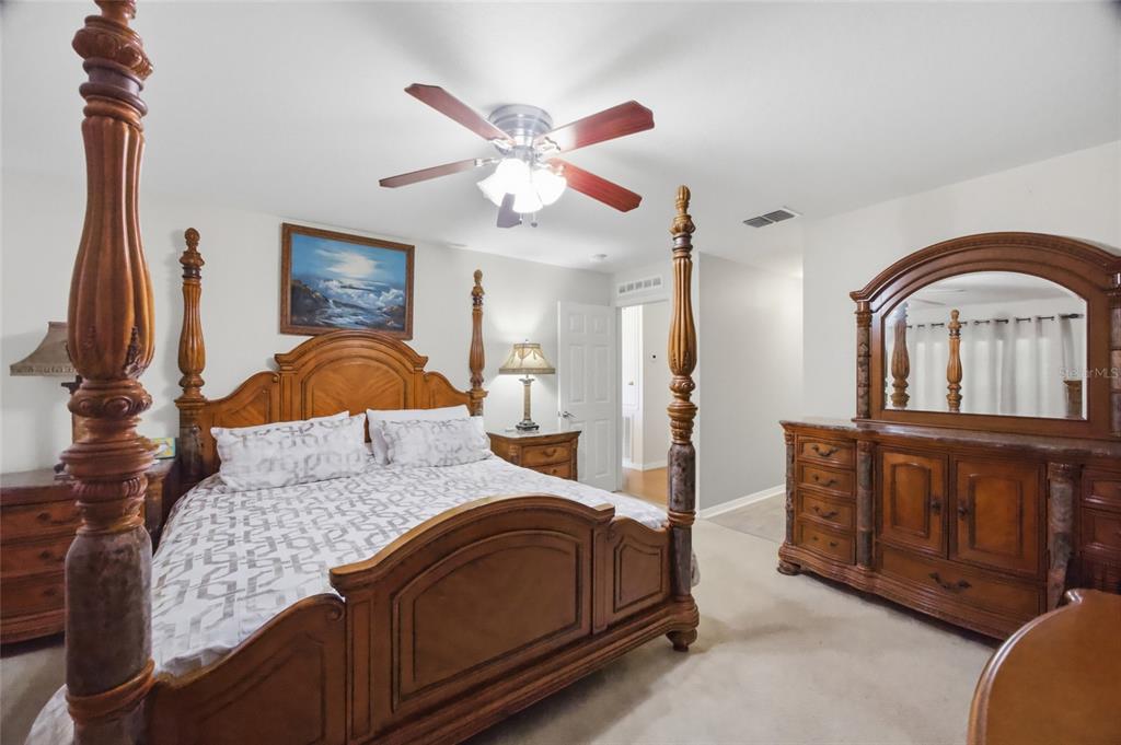 4517 Southeast 28th Street Ocala, FL 34480 - Photo 19 of 43 a bedroom with a large bed and a chandelier