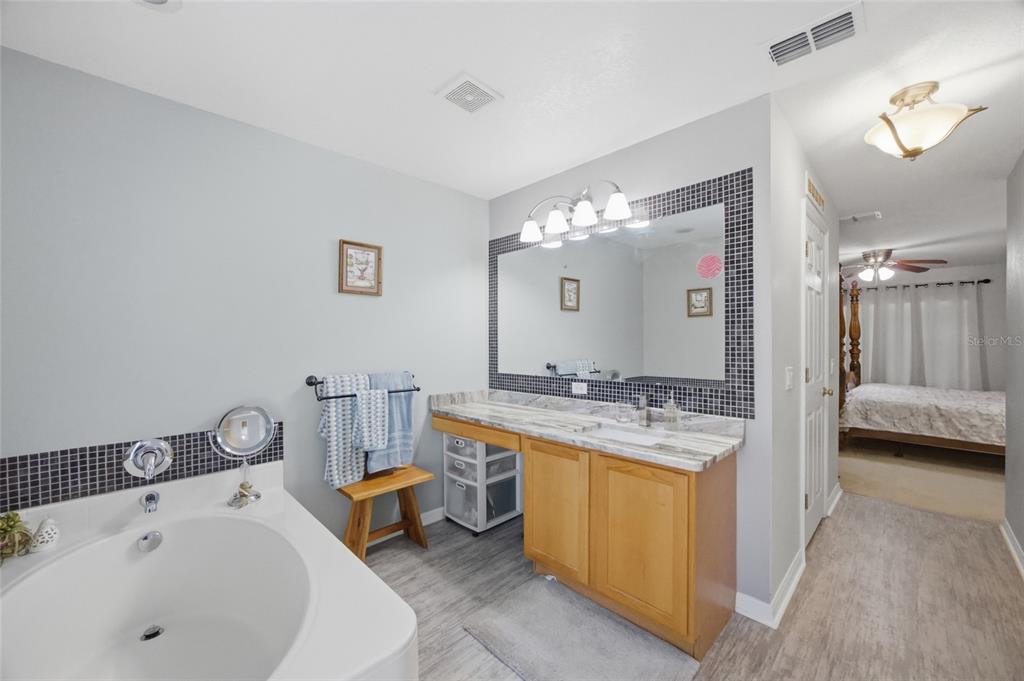 4517 Southeast 28th Street Ocala, FL 34480 - Photo 21 of 43 a en suite bathroom with a sink and a large mirror