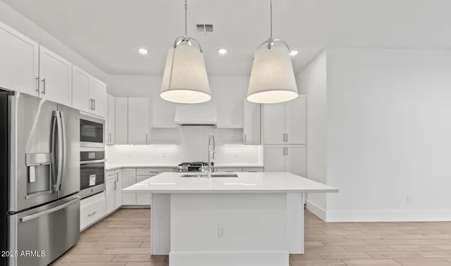 a kitchen with a sink dishwasher and white cabinets