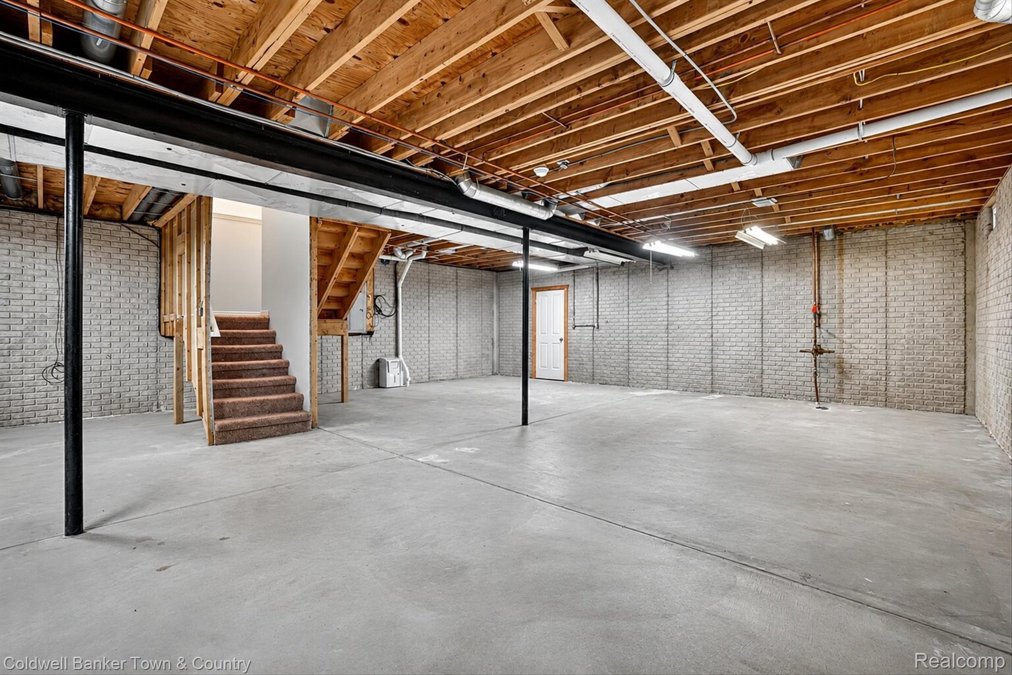 1725 Town Commons Drive Howell, MI 48855 - Photo 46 of 53 Unfinished basement featuring exposed wood joists, concrete flooring, and brick-patterned foundation walls