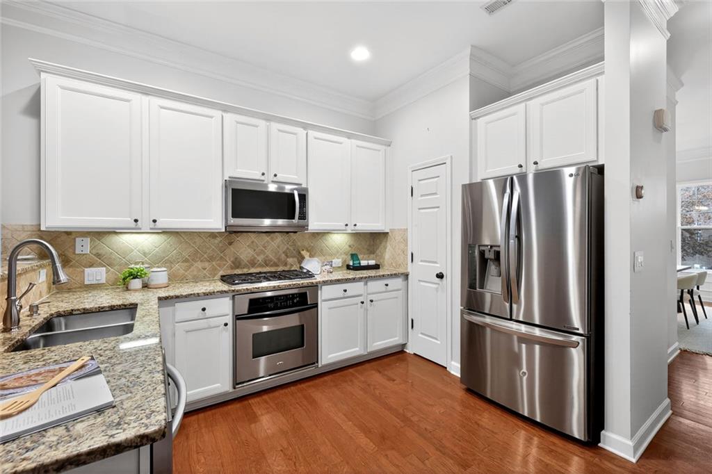1982 Cobblestone Circle Northeast Brookhaven, GA 30319 - Photo 11 of 51 a kitchen with granite countertop stainless steel appliances and wooden cabinets