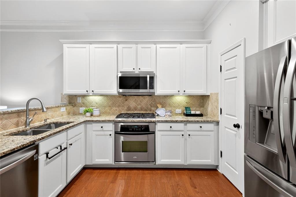 1982 Cobblestone Circle Northeast Brookhaven, GA 30319 - Photo 14 of 51 a kitchen with stainless steel appliances granite countertop white cabinets a sink a stove a refrigerator and a microwave