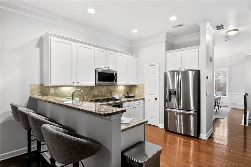 1982 Cobblestone Circle Northeast Brookhaven, GA 30319 - Photo 10 of 51 a kitchen with stainless steel appliances granite countertop a refrigerator a stove a sink a dining table and chairs with wooden floor