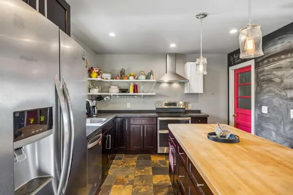 a kitchen with stainless steel appliances granite countertop a sink a stove and a refrigerator