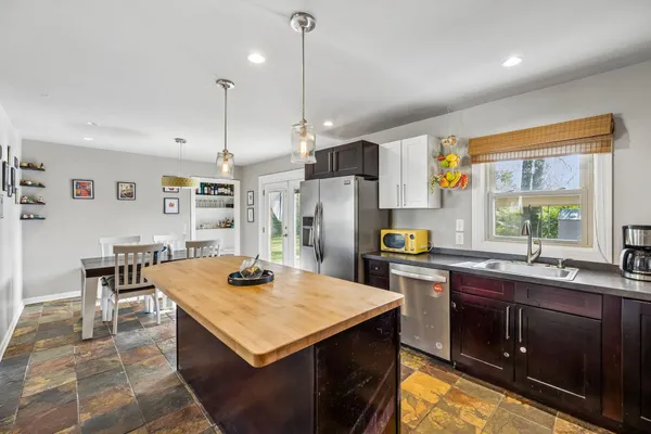 a kitchen with stainless steel appliances granite countertop a sink a stove and a refrigerator