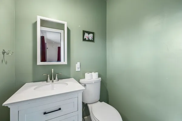 a bathroom with a sink mirror and toilet