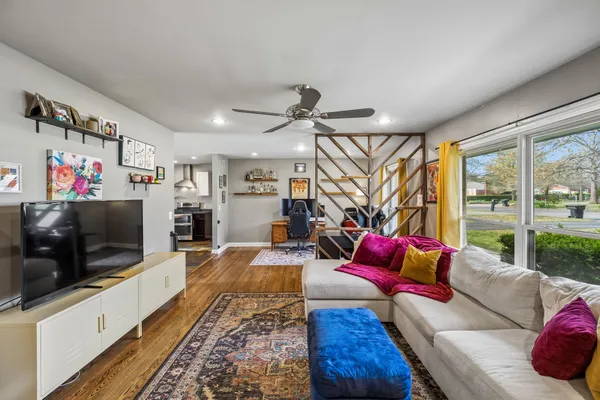 a living room with furniture a flat screen tv and a floor to ceiling window