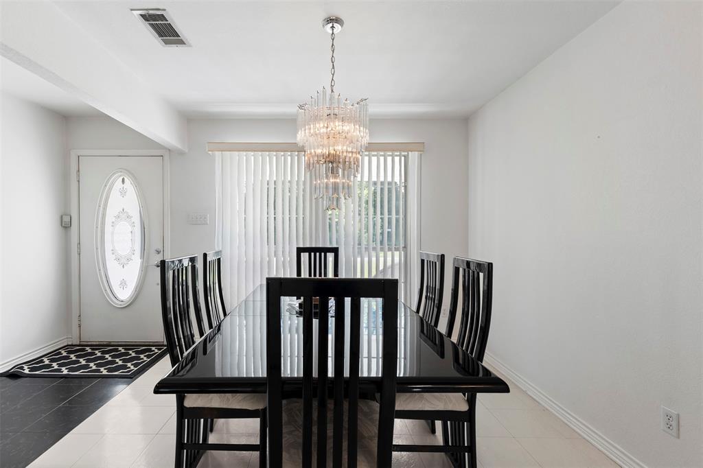 401 Rugged Drive Red Oak, TX 75154 - Photo 11 of 40 Formal dining space featuring a polished black table and a multi-tiered crystal chandelier