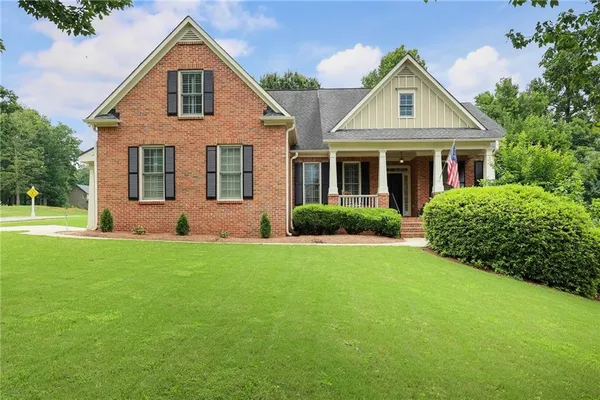 a front view of a house with a yard and trees