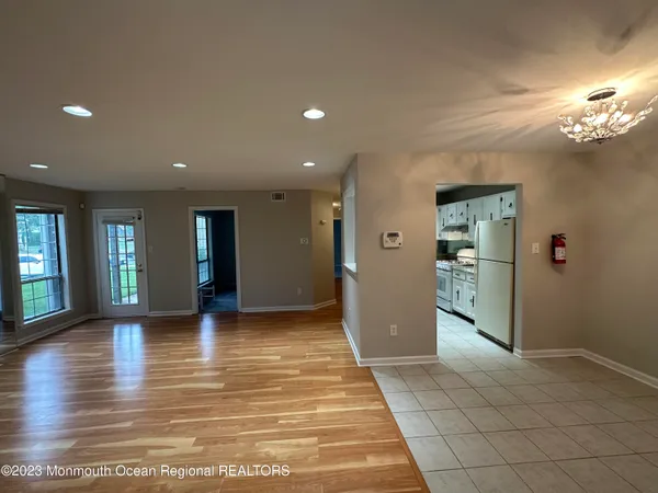 a view of hallway with wooden floor and a living room