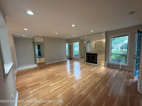 an empty room with wooden floor and fireplace