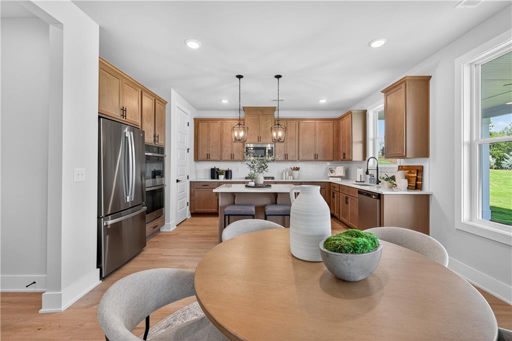 2541 Parkside Way Gainesville, GA 30507 - Photo 6 of 45 a kitchen with stainless steel appliances granite countertop a refrigerator a stove a sink dishwasher a dining table and chairs with wooden floor