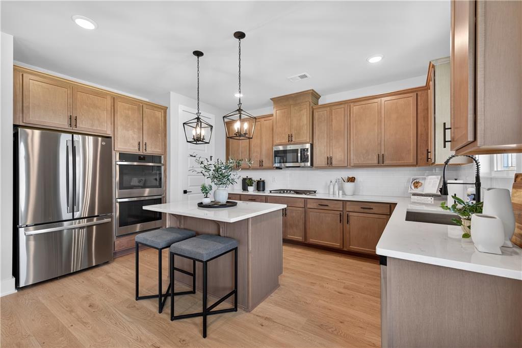 2541 Parkside Way Gainesville, GA 30507 - Photo 8 of 45 a kitchen with stainless steel appliances granite countertop a sink a stove a refrigerator and island with wooden floor