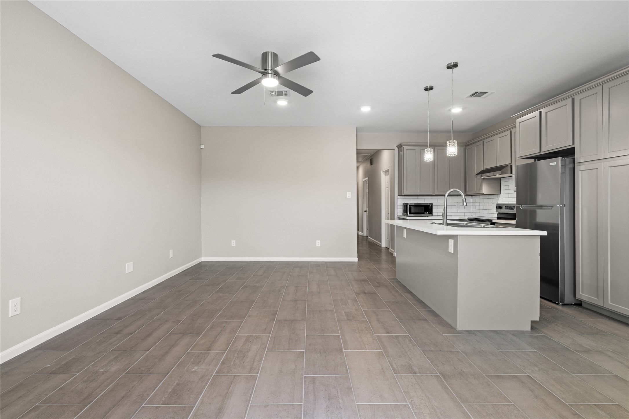 142 Calloway Street, Unit A Houston, TX 77029 - Photo 13 of 23 a view of a kitchen with wooden floor and a refrigerator