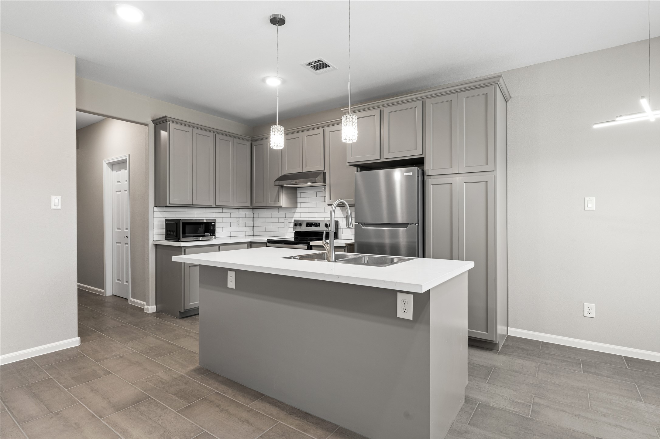 142 Calloway Street, Unit A Houston, TX 77029 - Photo 4 of 23 a kitchen with kitchen island a sink stainless steel appliances and refrigerator