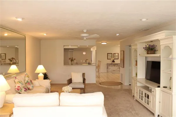 a living room with furniture a flat screen tv and a chandelier