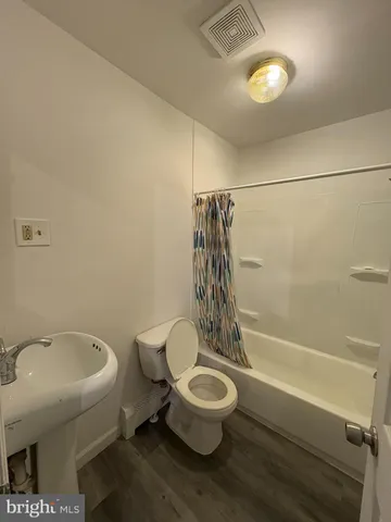 a white toilet sitting next to a bath tub