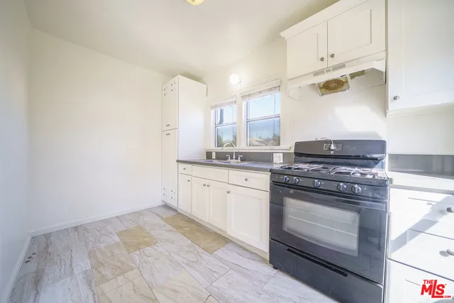 a kitchen with granite countertop white cabinets and white appliances