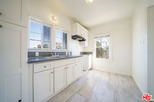 a spacious bathroom with a granite countertop sink and a mirror