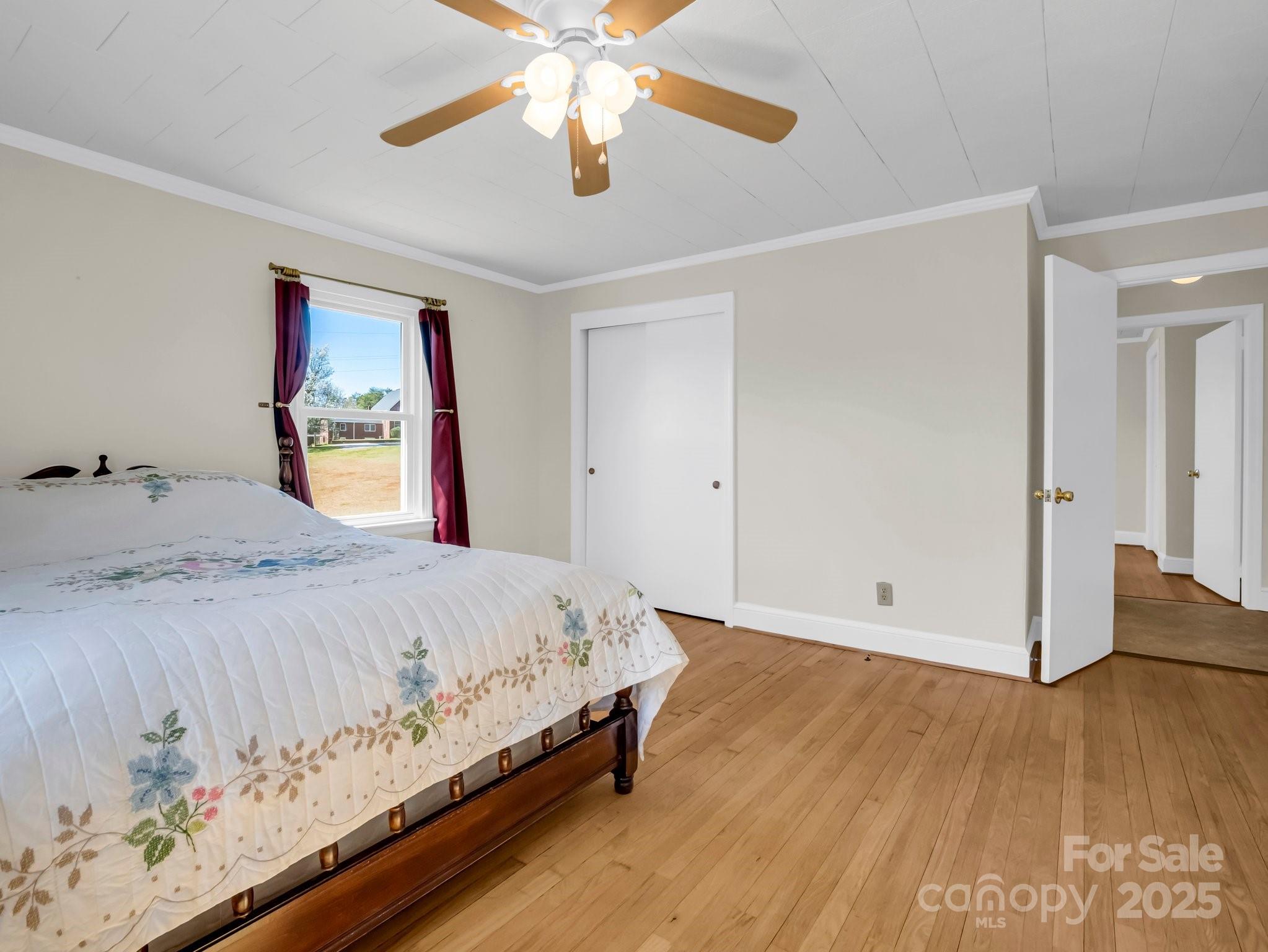 34 Manus Chapel Road Mill Spring, NC 28756 - Photo 29 of 42 a bedroom with a large bed and a chandelier