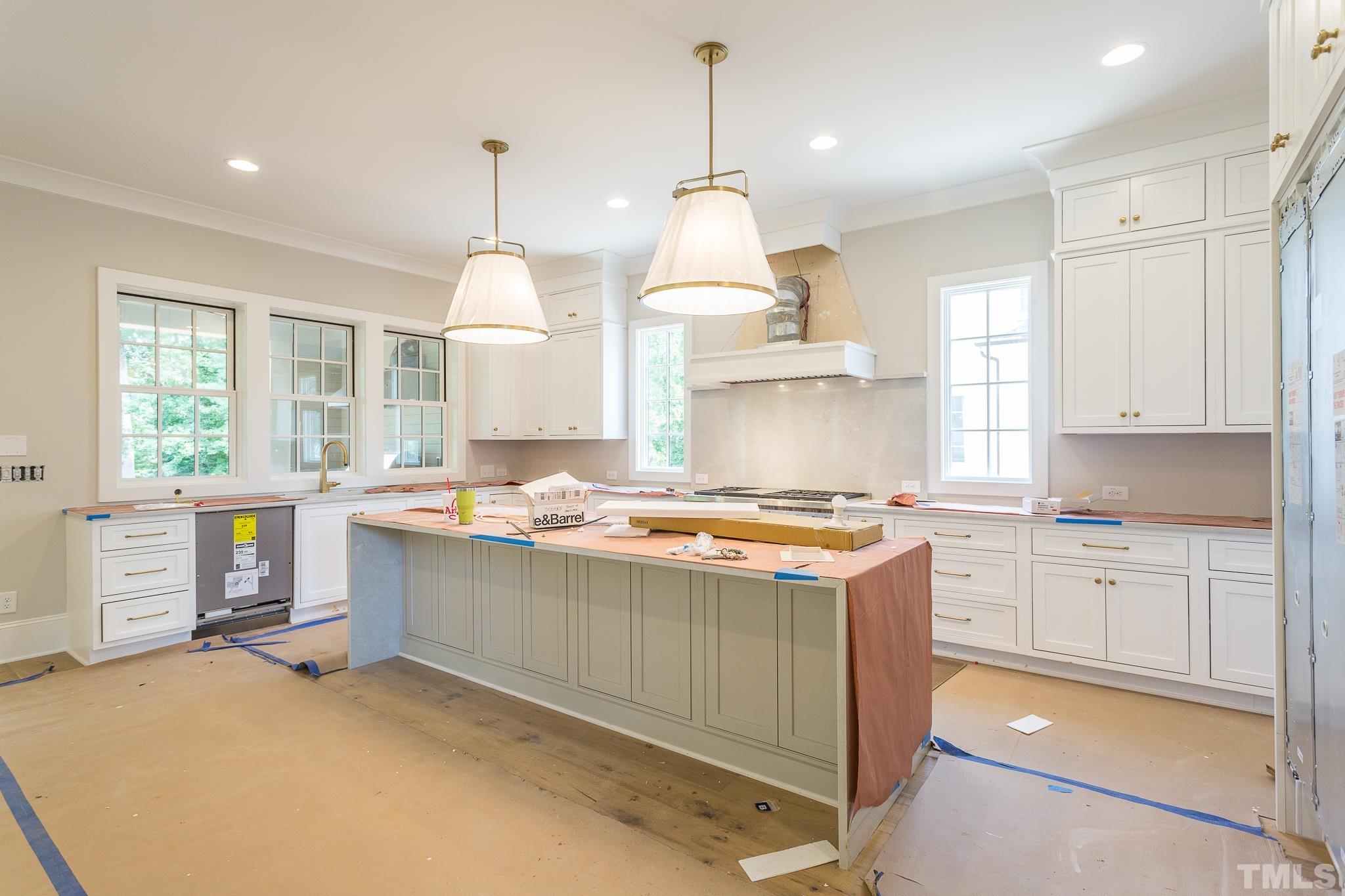 3126 Sussex Road Raleigh, NC 27612 - Photo 16 of 36 a kitchen with a stove a sink a center island and windows