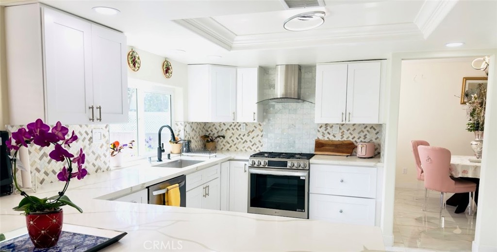 10452 Circulo De Juarez Fountain Valley, CA 92708 - Photo 10 of 34 a kitchen with granite countertop a sink stove and cabinets