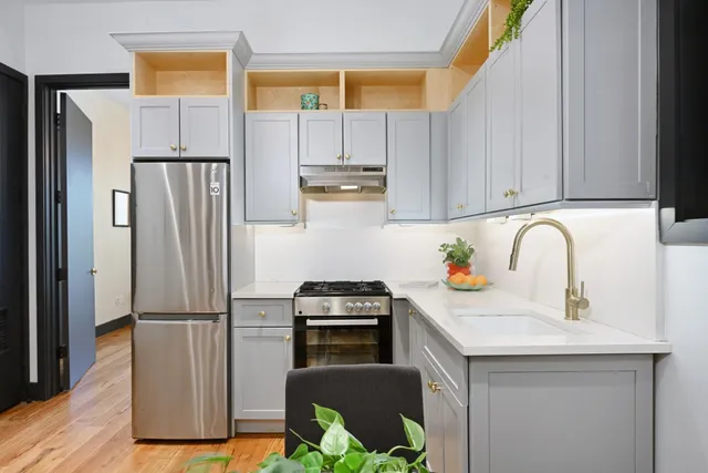a kitchen with a refrigerator sink and cabinets