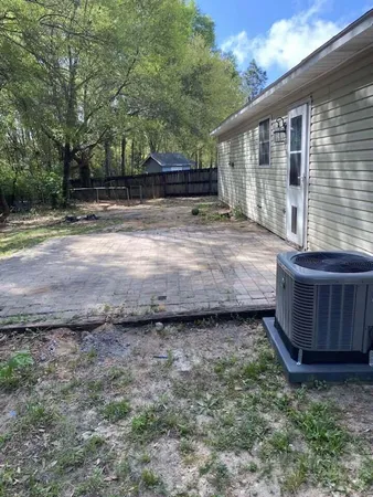 a view of a backyard with large trees and wooden fence