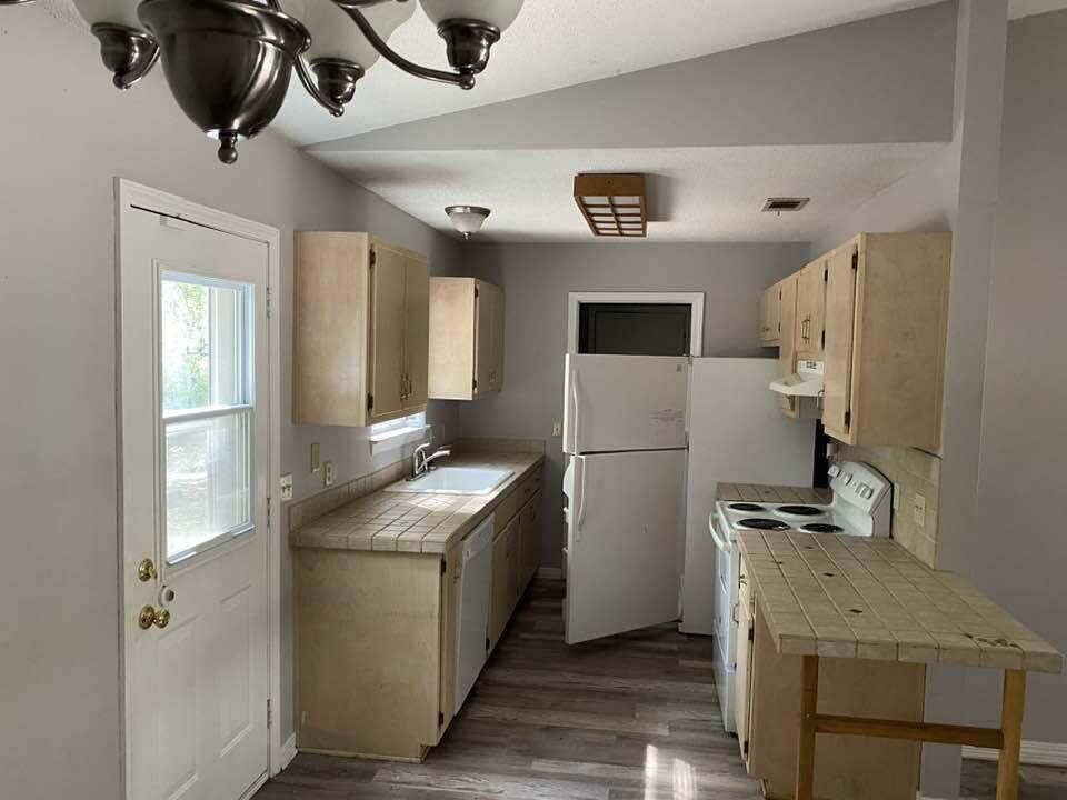 12 Flora Cove Crestview, FL 32539 - Photo 3 of 16 a kitchen with a refrigerator a stove top oven a sink and a window