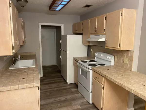 a kitchen with a stove a sink and a refrigerator
