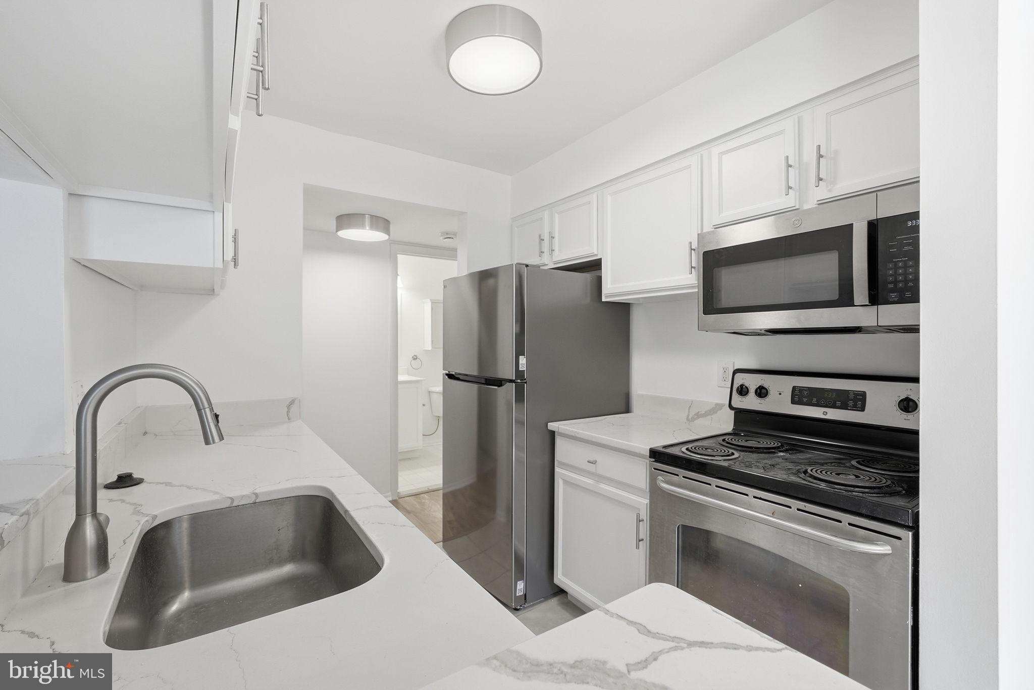 1703 Ascot Way, Unit D Reston, VA 20190 - Photo 11 of 21 a kitchen with granite countertop a sink stainless steel appliances and cabinets