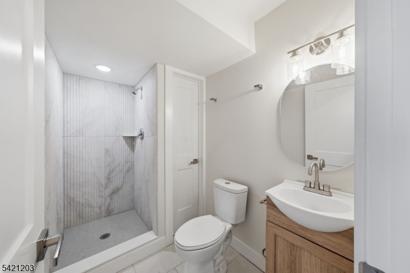 33 Clinton Place Morristown, NJ 07960 - Photo 16 of 24 a bathroom with a shower a sink mirror and toilet