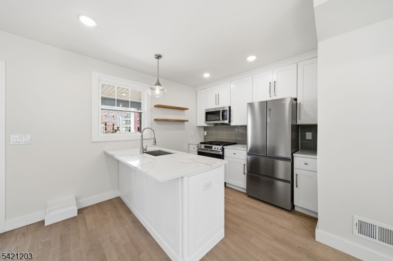 33 Clinton Place Morristown, NJ 07960 - Photo 3 of 24 a kitchen with a refrigerator a stove top oven a sink and a center island