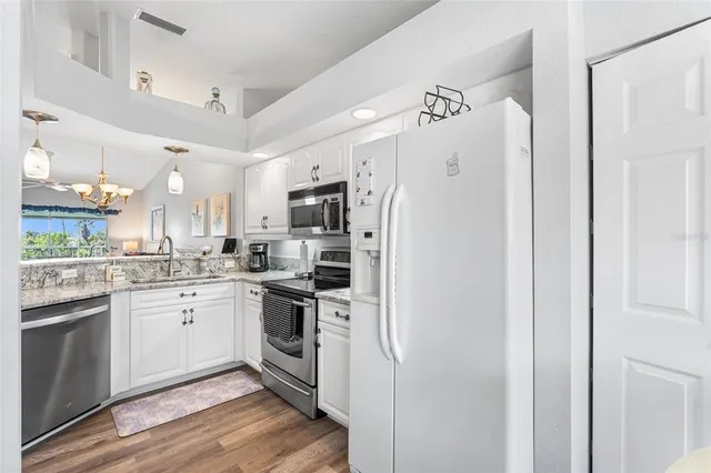 a kitchen with stainless steel appliances granite countertop a sink stove oven and white cabinets