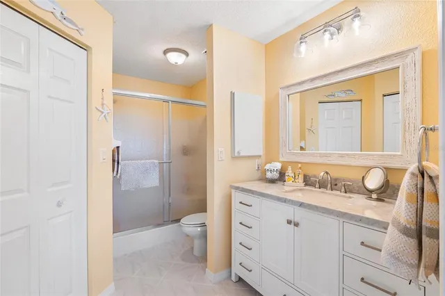 a en suite bathroom with a granite countertop sink and a mirror