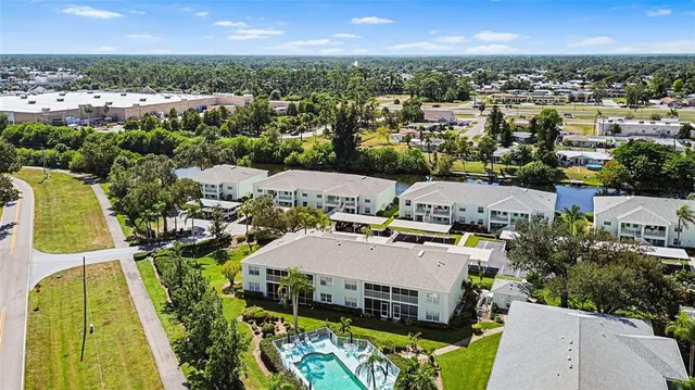 an aerial view of a multi story residential apartment building with a yard