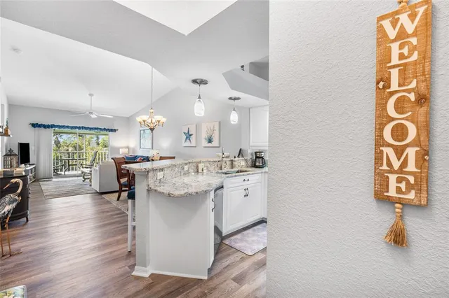 a kitchen with stainless steel appliances kitchen island granite countertop a table and chairs in it
