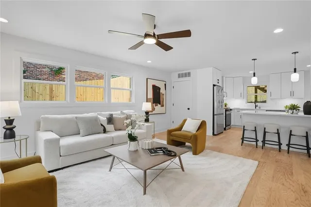 a living room with furniture kitchen view and a window