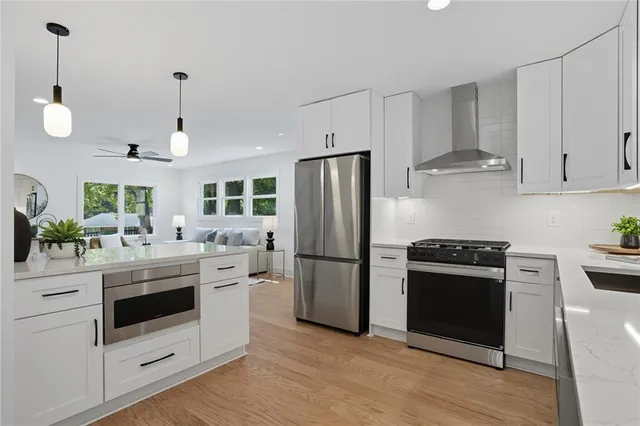 a kitchen with kitchen island white cabinets and stainless steel appliances