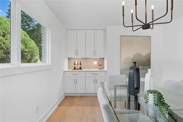 a kitchen with white cabinets and window