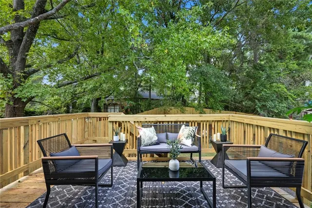 a view of deck with furniture and trees